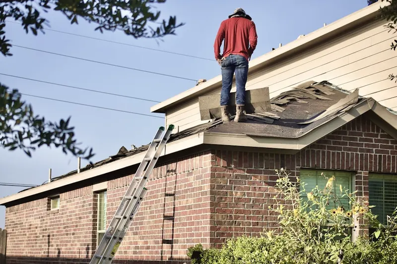 Professional roofer working on a residential roof in Quaker Heights